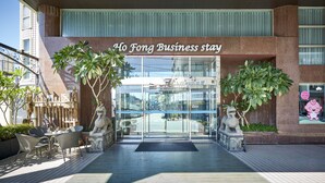 Hotellets indgang med et skilt, der viser 'Ho Fong Business Stay'.
