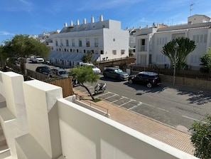 A residential street with white buildings, parked cars, and a clear sky. - Apartamentos Eugenio by Formentera Passport (Formentera)