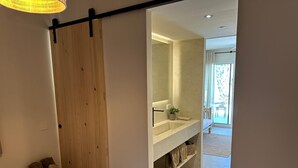 Un baño moderno con un espejo grande, un lavabo y una planta en maceta.
