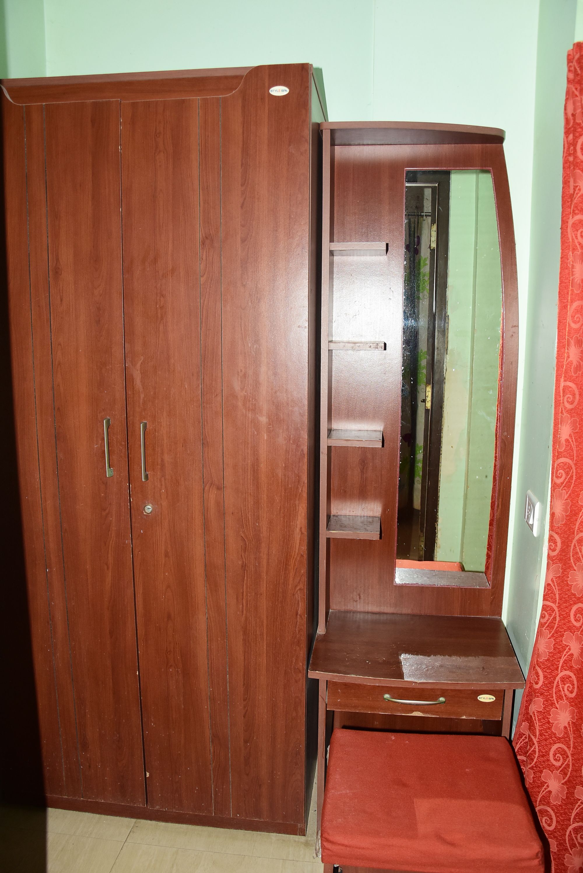 Un armario de madera con dos puertas y un espejo.