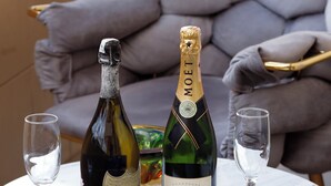 A bottle of Moët & Chandon champagne and two glasses on a marble table with a gold frame, set in a room with a grey upholstered chair and a patterned rug. - Turk Art Hotel (Istanbul)