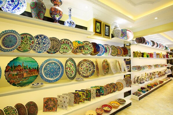A store with shelves of colorful plates and vases. - Turk Art Hotel (Istanbul)