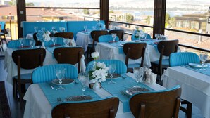A restaurant with tables set for dining, featuring a view of the cityscape. - Turk Art Hotel (Istanbul)