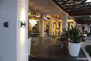 A modern indoor area with seating arrangements and a large potted plant.