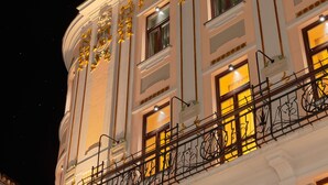 A building facade with ornate gold decorations, large windows, and a balcony with intricate black railings. - Piazza Heritage Hotel (Split)