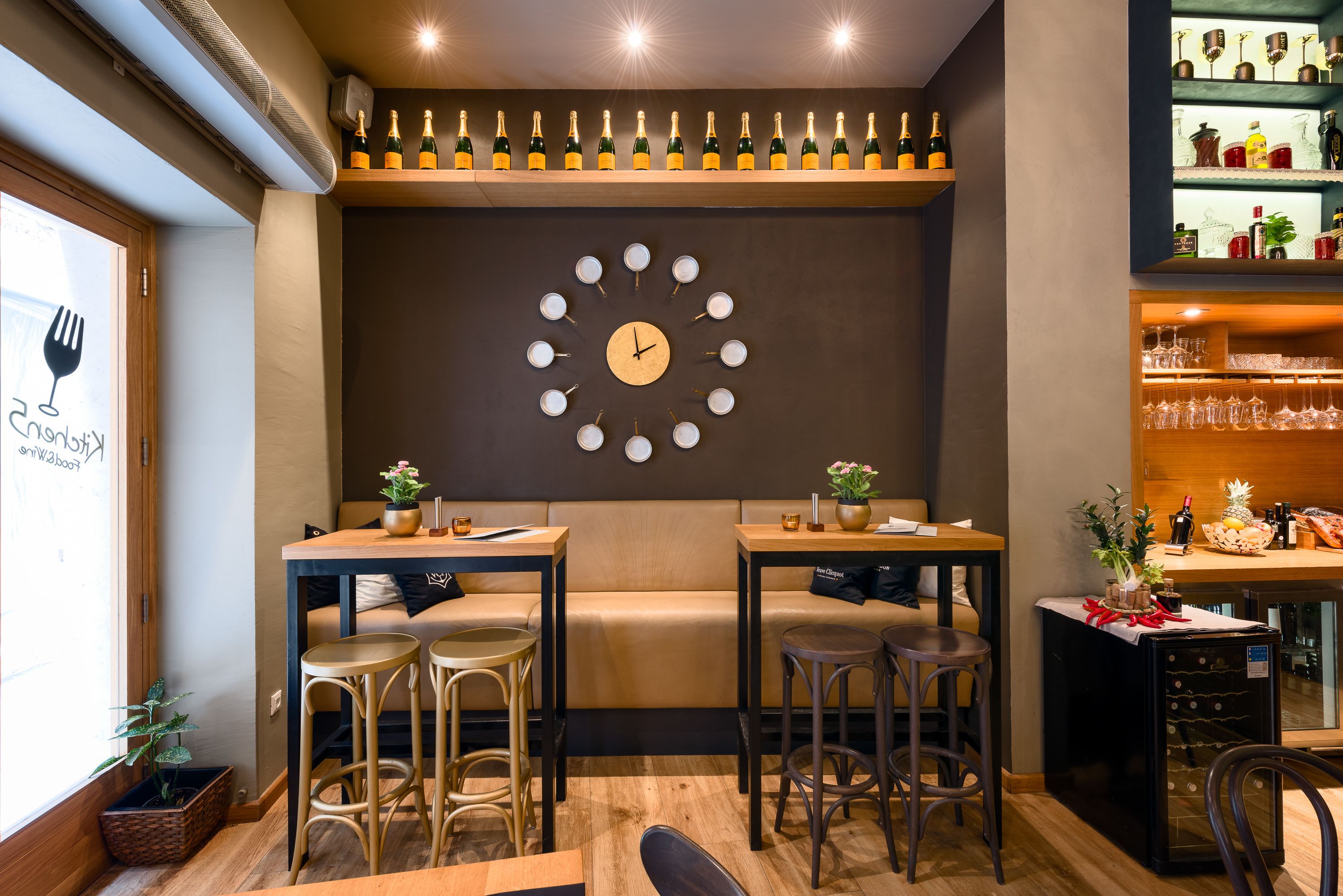Un accogliente ristorante con due cabine, una sveglia a parete e un ripiano con bottiglie.
