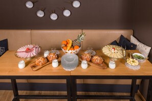 Guests can enjoy a meal at the dining table, which is set with a variety of food items and glasses.