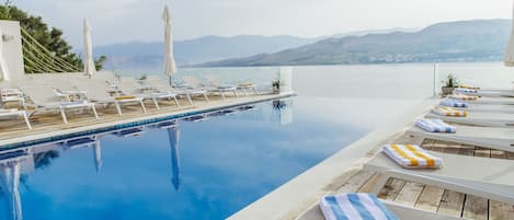 Una piscina al aire libre de temporada, sombrillas