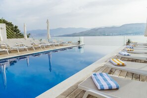 Una piscina al aire libre de temporada, sombrillas