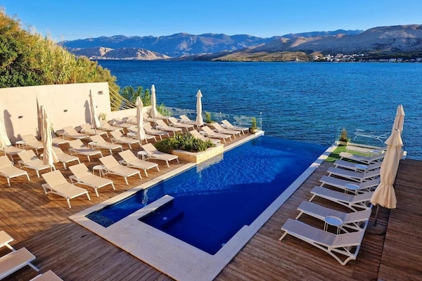 Una piscina al aire libre de temporada, sombrillas