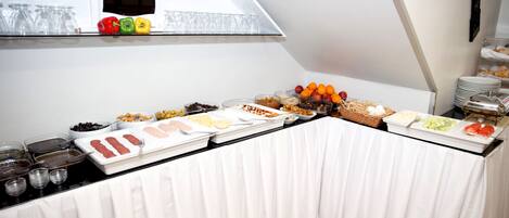 Una mesa de buffet con diversos alimentos y una vitrina encima.