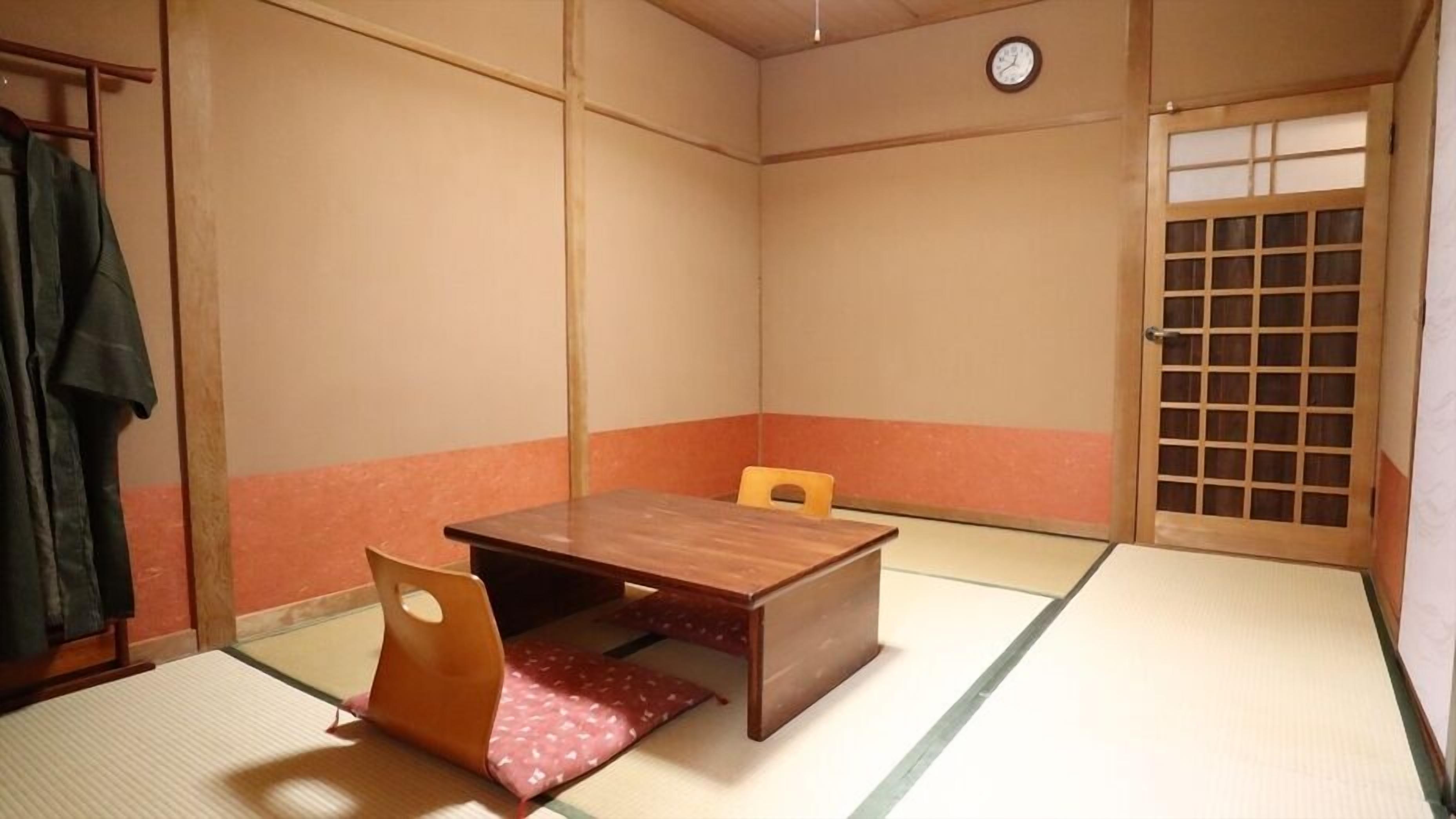 A traditional Japanese room with tatami flooring, a wooden table, and a shoji screen door.