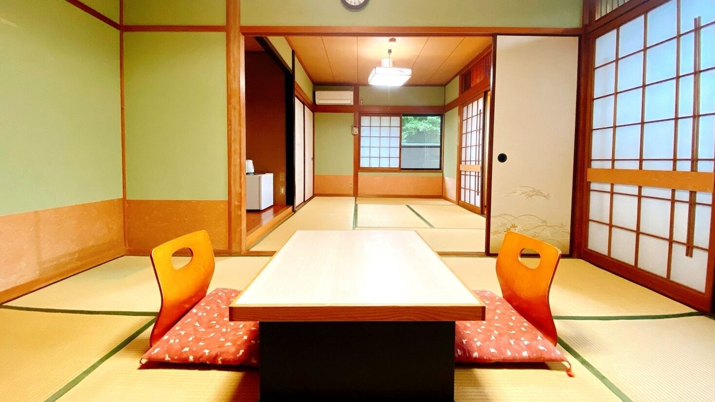 A traditional Japanese room with tatami flooring, a low table, and sliding doors.