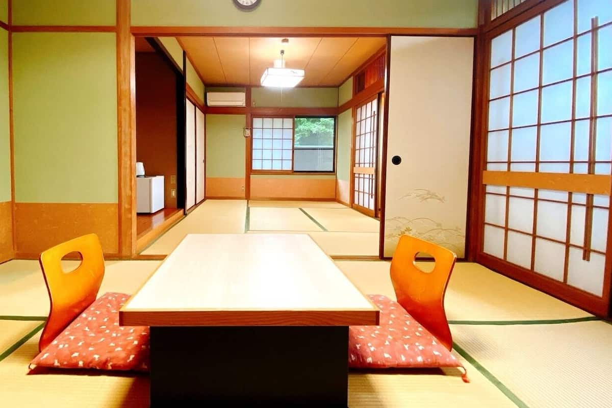 A traditional Japanese room with tatami flooring, a low table, and sliding doors.
