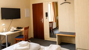 A hotel room with two beds, a desk, a chair, a television, and a wardrobe. - Hotel Select (Moenchengladbach)