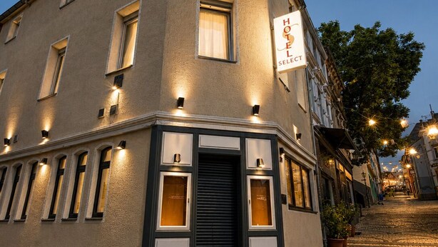 A hotel with a corner entrance, multiple windows, and a sign indicating it is a hotel. - Hotel Select (Moenchengladbach)