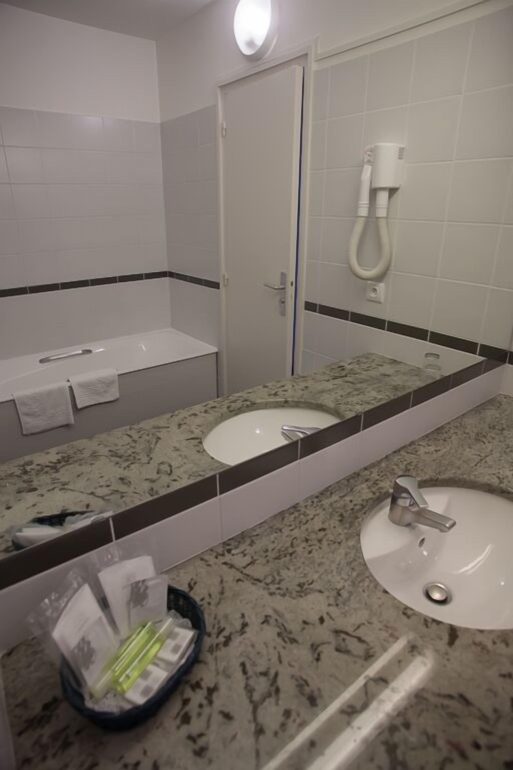 Un baño con dos lavamanos, un espejo, toallero y ducha.