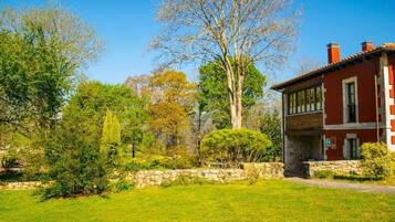 A red building with a stone wall and a grassy lawn.