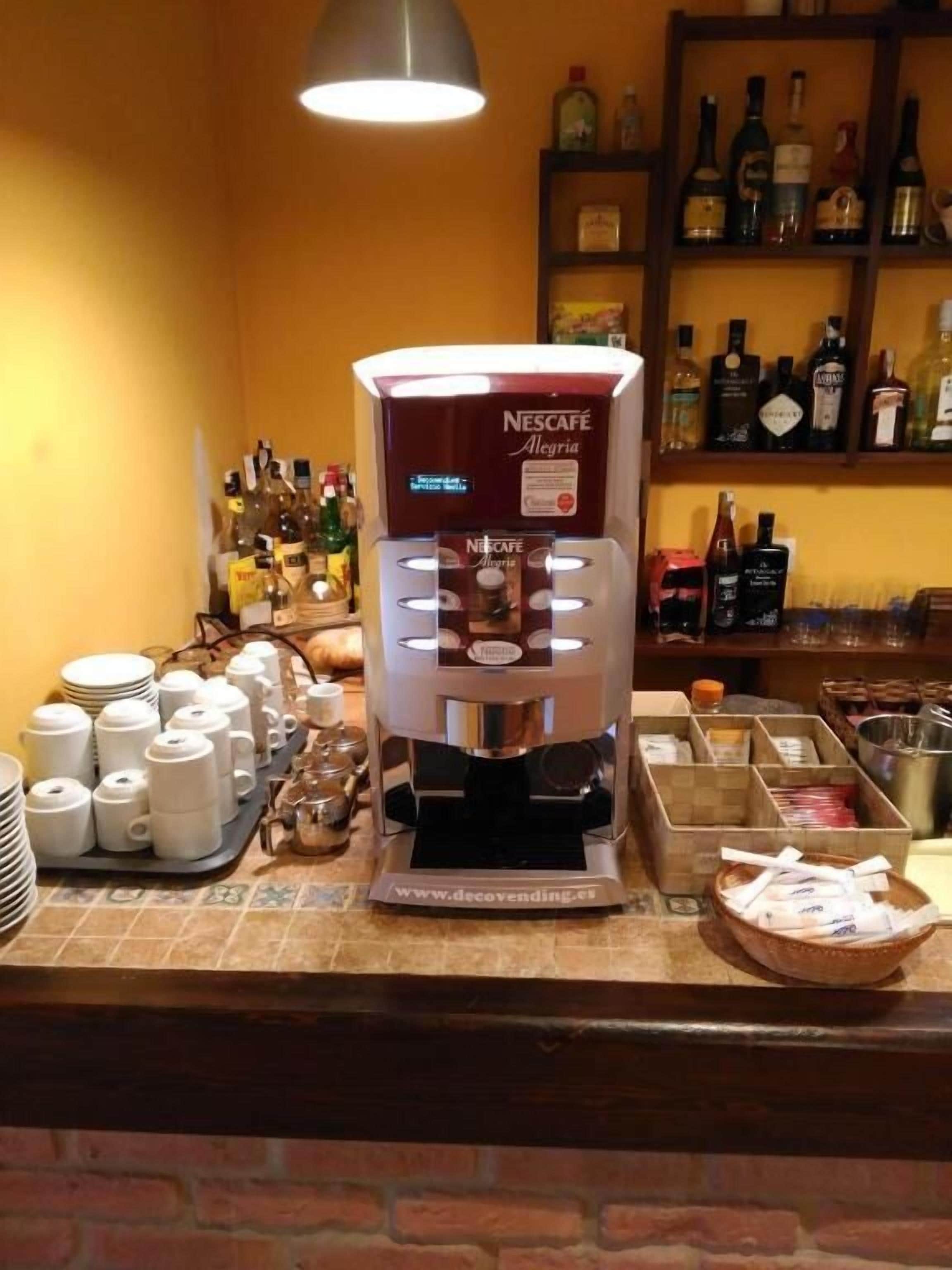 A coffee machine with multiple dispensing options, a variety of coffee pods, and a selection of coffee cups on a counter.