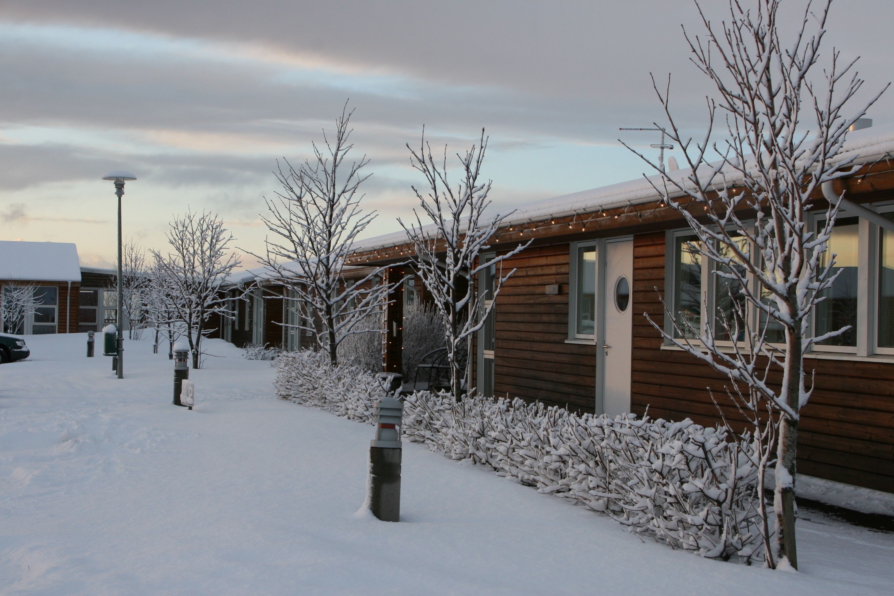Een houten gebouw met een buitenkant bedekt met sneeuw en een heldere lucht.