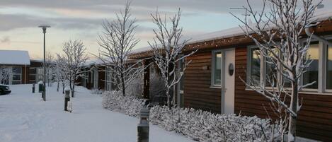 Een houten gebouw met een buitenkant bedekt met sneeuw en een heldere lucht.