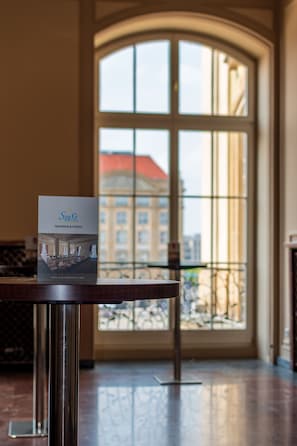 A hotel reception area with a large arched window, a reception desk, and a sign for StarG Hotel's tagungs & events.