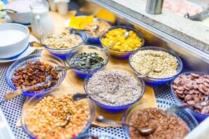 A buffet with various food items in bowls, including cereals, nuts, and fruits. - Hotel Gschwangut (Lana)
