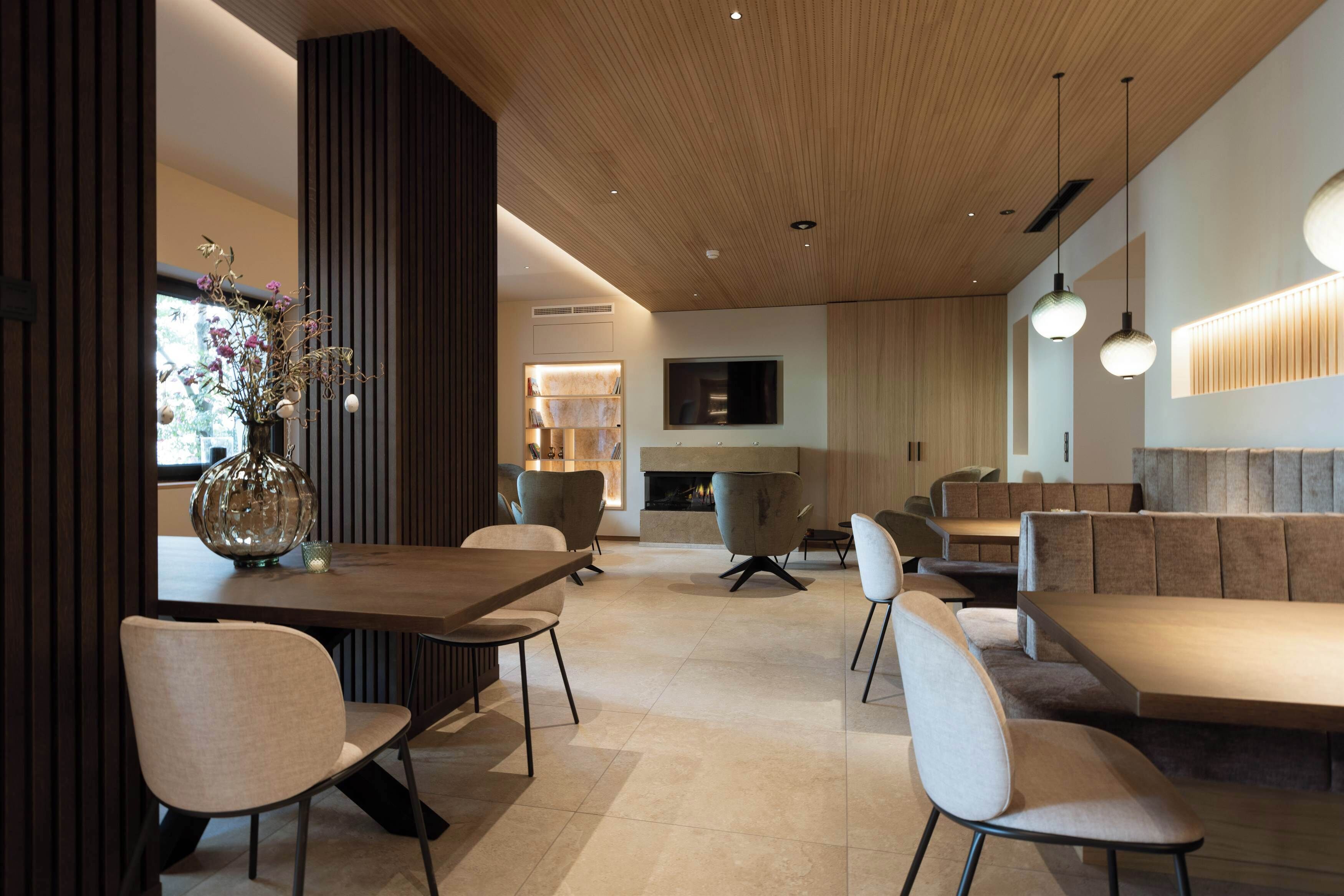 Um interior moderno com área de jantar, assentos e lareira.