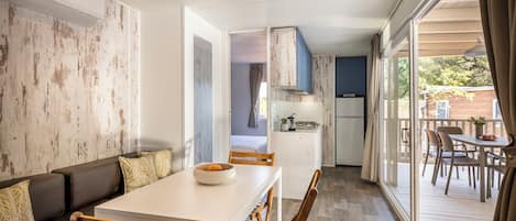 Una cocina moderna con encimera blanca, sillas de madera y una mesa de comedor.