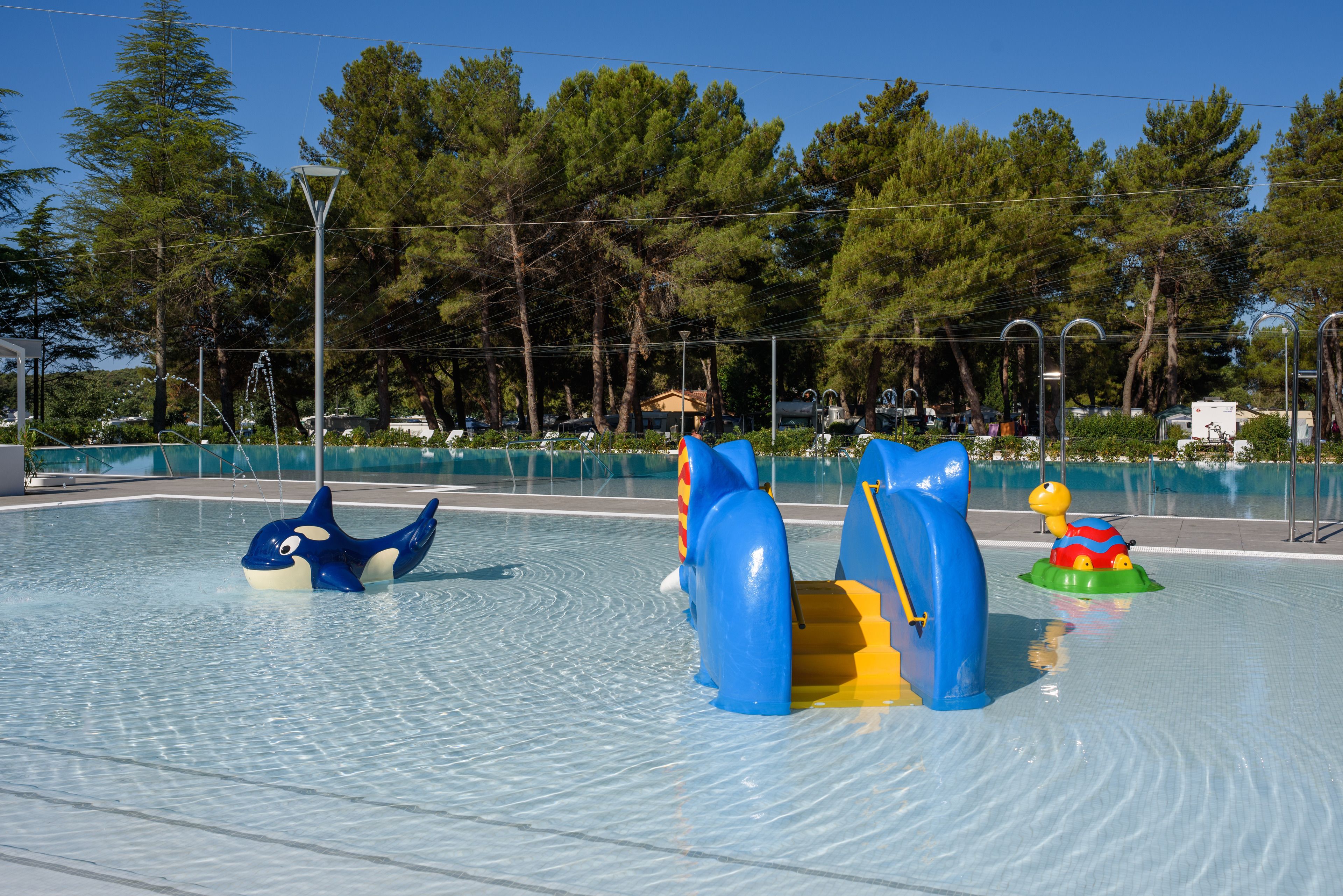 A water play area with inflatable slides and pools.