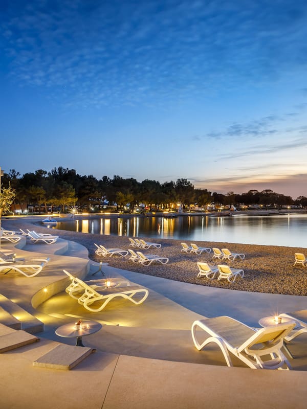 Relax by the pool surrounded by a pebble beach.
