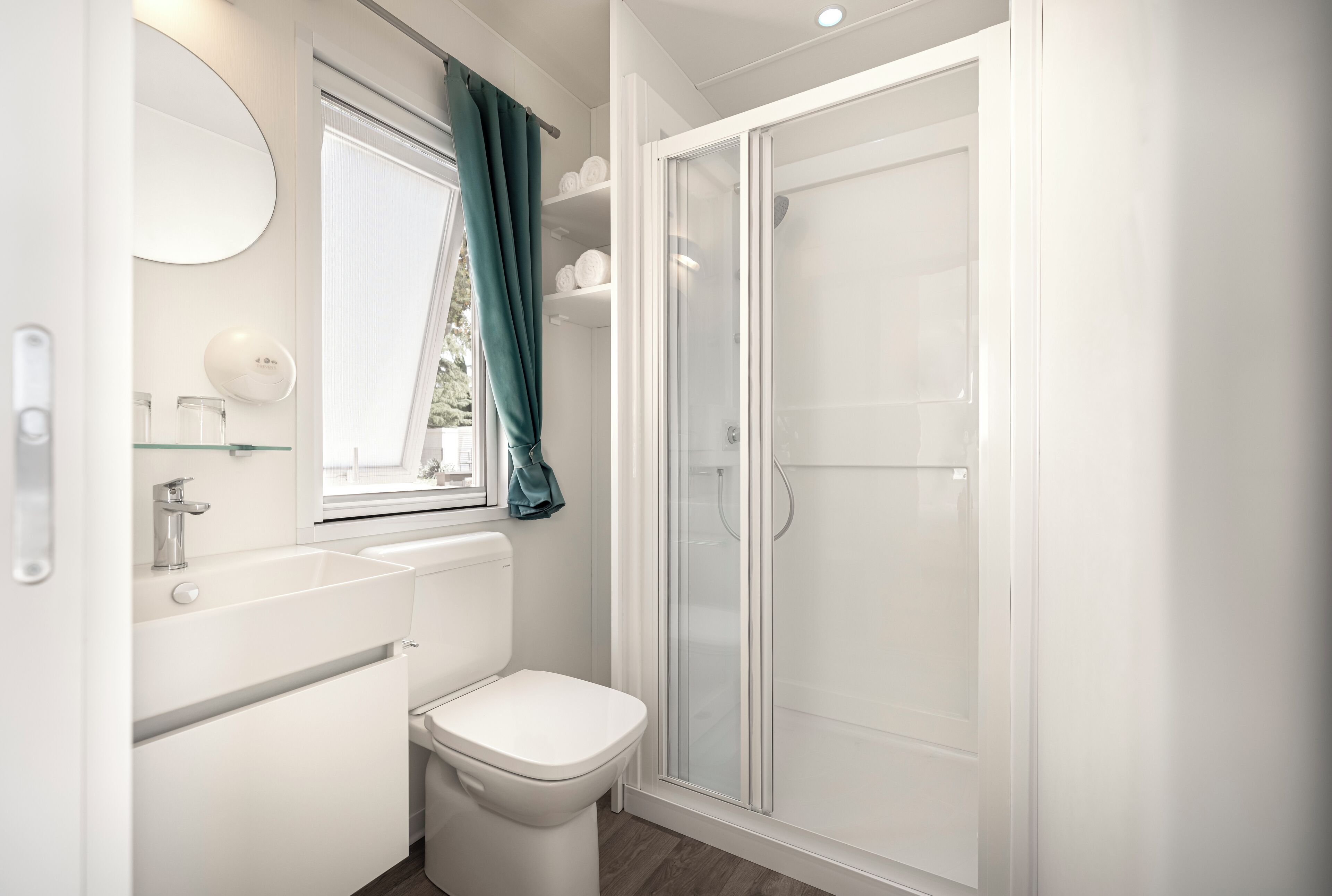 A modern bathroom with a toilet, sink, and shower.