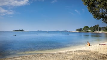 On the beach, sun-loungers, beach umbrellas, surfing