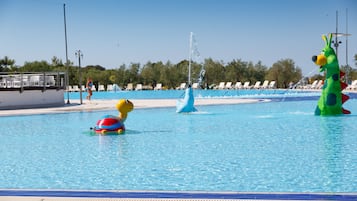 Relax by the pool with lounge chairs and umbrellas, surrounded by a soothing water fountain.