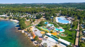 An aerial view of a coastal resort with a beach, swimming pools, and a water park. - Maistra Camping Polari Mobile homes   (Rovinj)