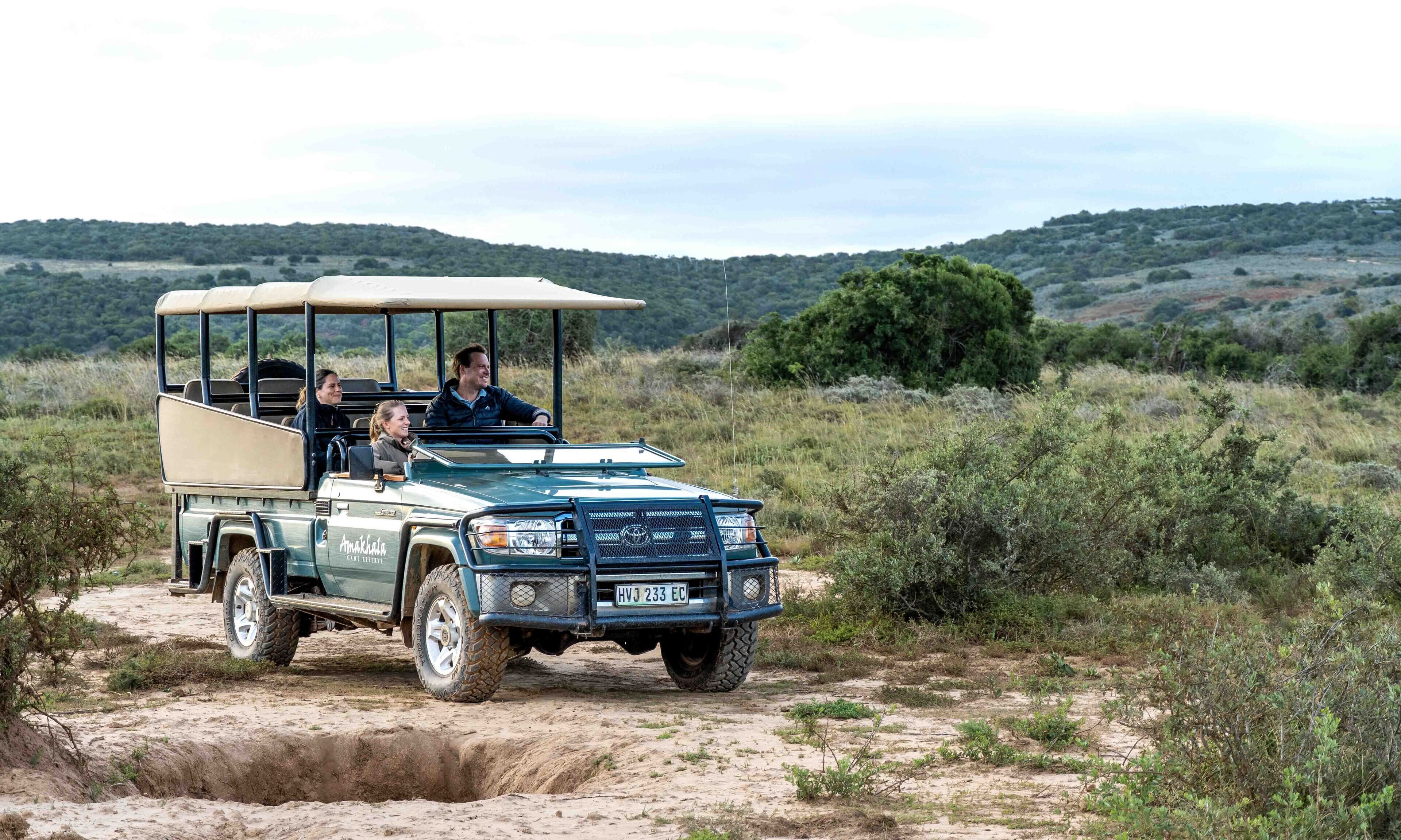 A safari vehicle on a dirt path in a natural landscape.