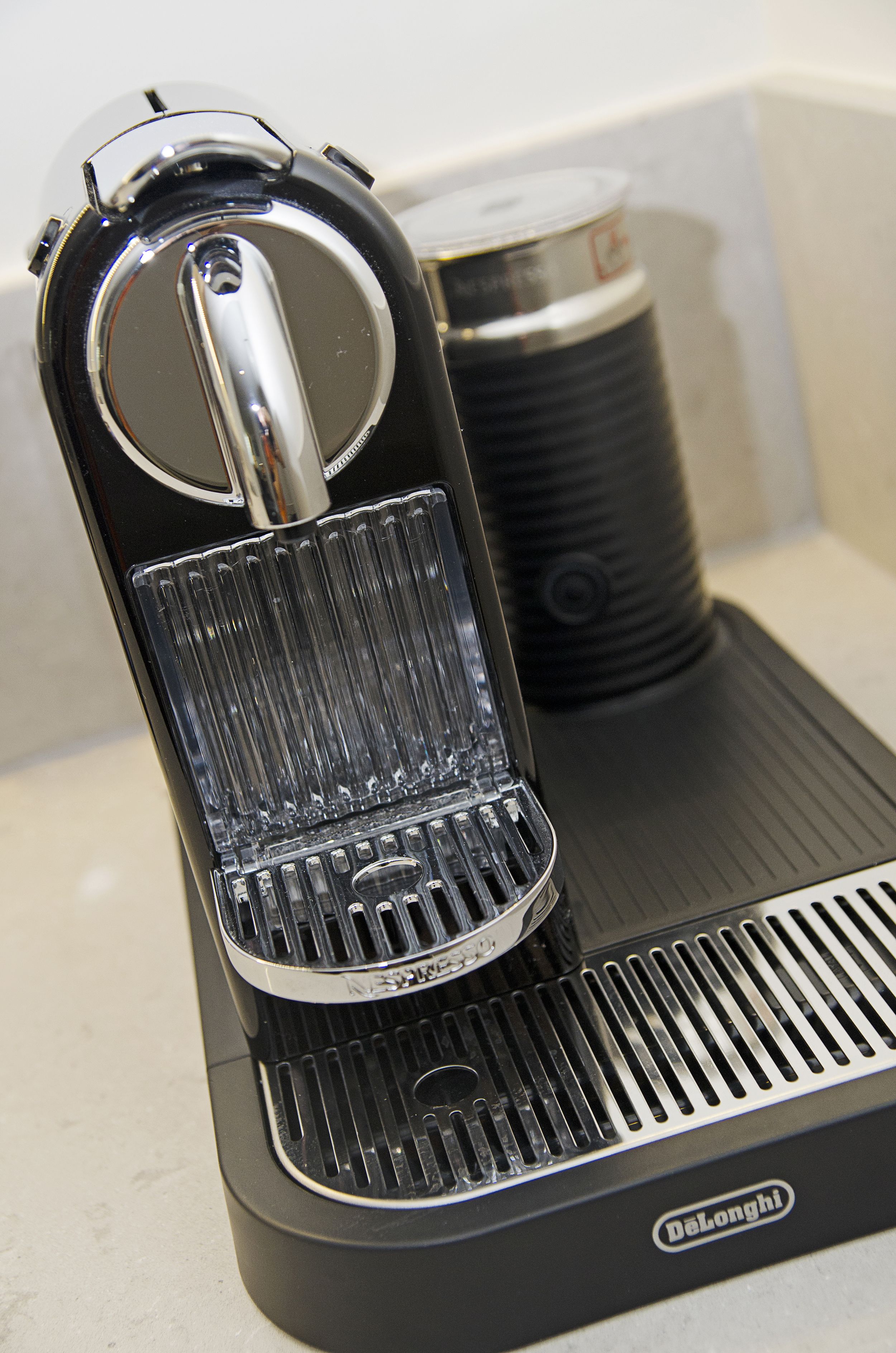 Una cafetera con depósito de agua transparente y bandeja para recoger las gotas.