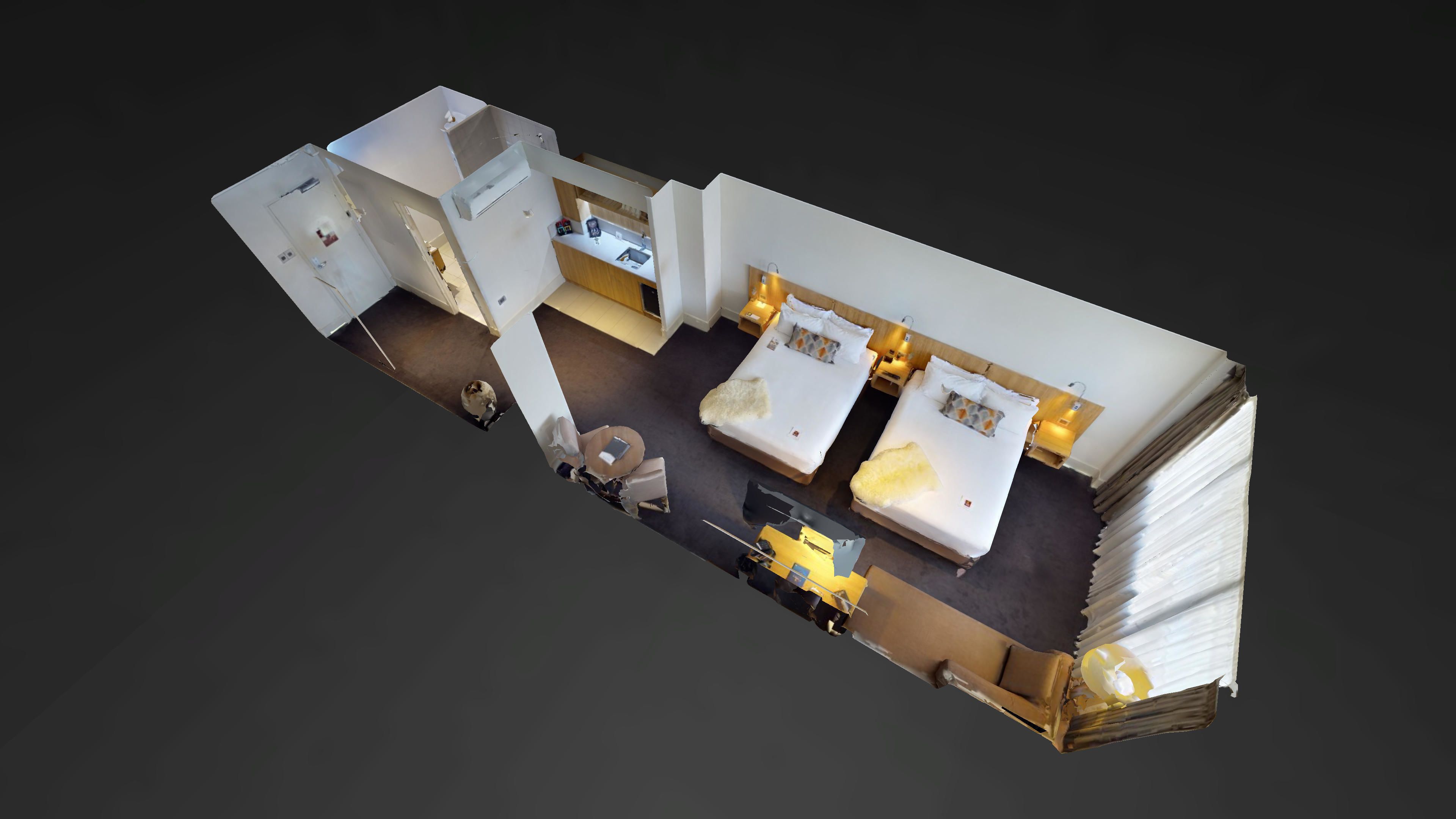 A 3D model of a hotel room with a bed, a desk, and a chair.