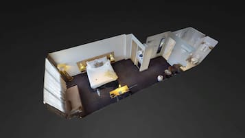 A hotel room with a bed, bedside table, lamp, and a small seating area.