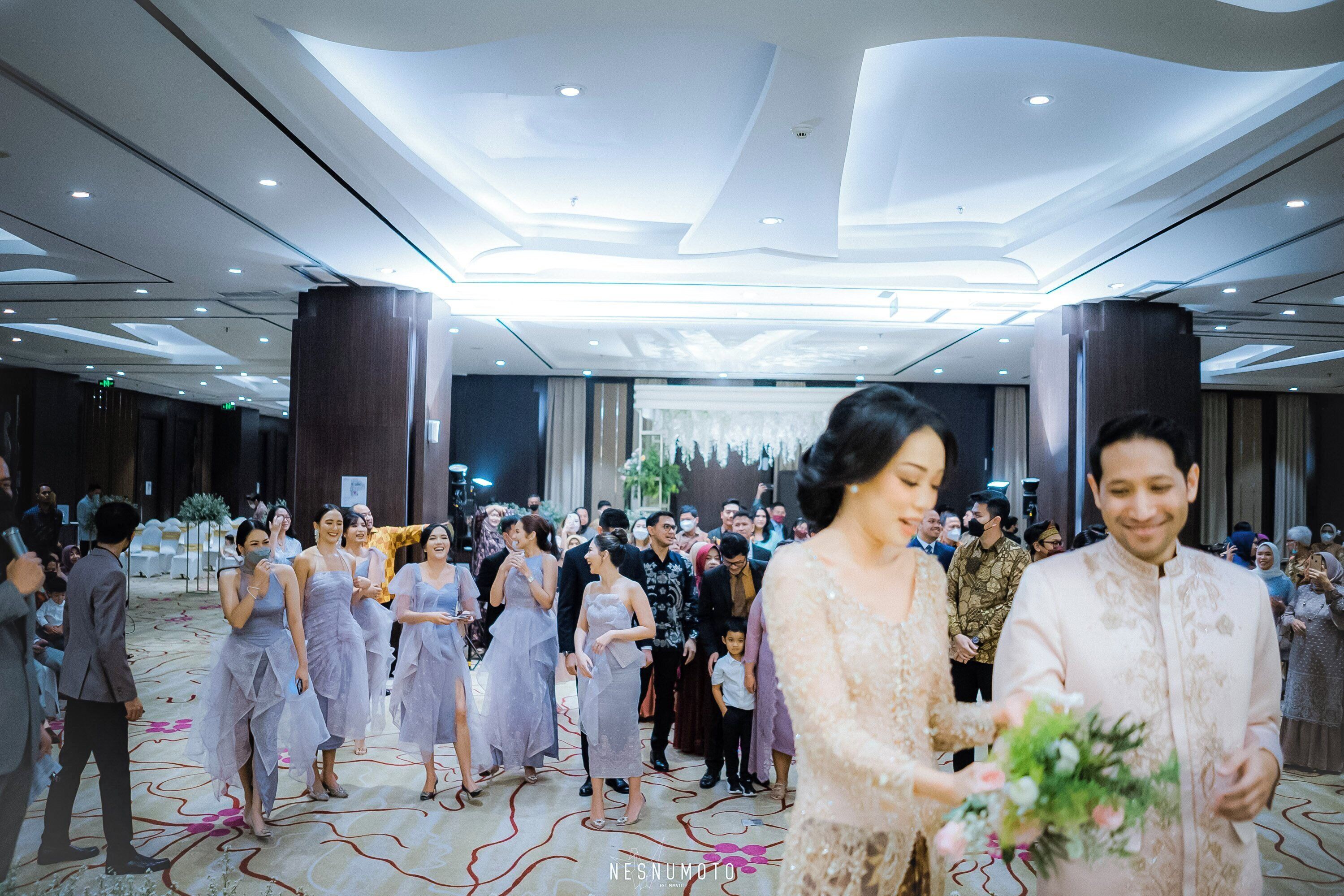 A formal event with a crowd in a spacious hall with a high ceiling and modern lighting.
