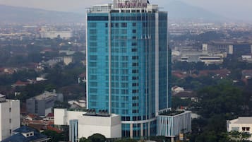 A tall blue glass building with a sign reading "CARPINE PLAZA" at the top.