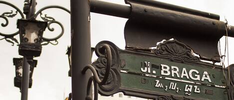 A street sign with the name "JI. Braga" and a lion statue.