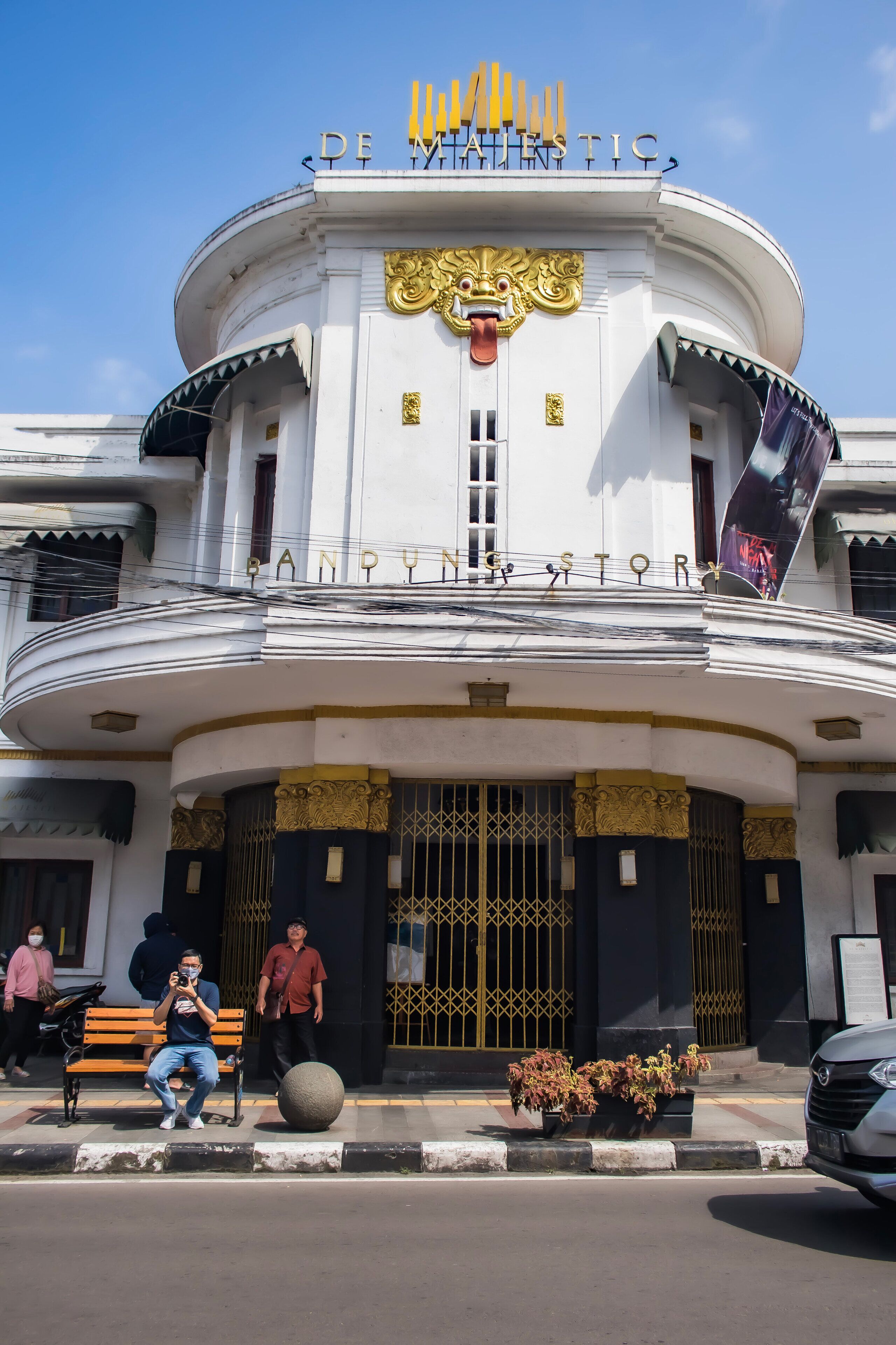 A building with a prominent sign reading 'DE MAJESTIC BANDUNG' and a large golden decorative element above the entrance.