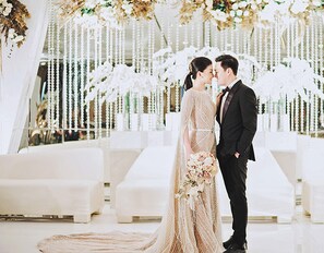 A wedding ceremony with a white floral backdrop and seating arrangements. - Crowne Plaza Bandung by IHG (Bandung)