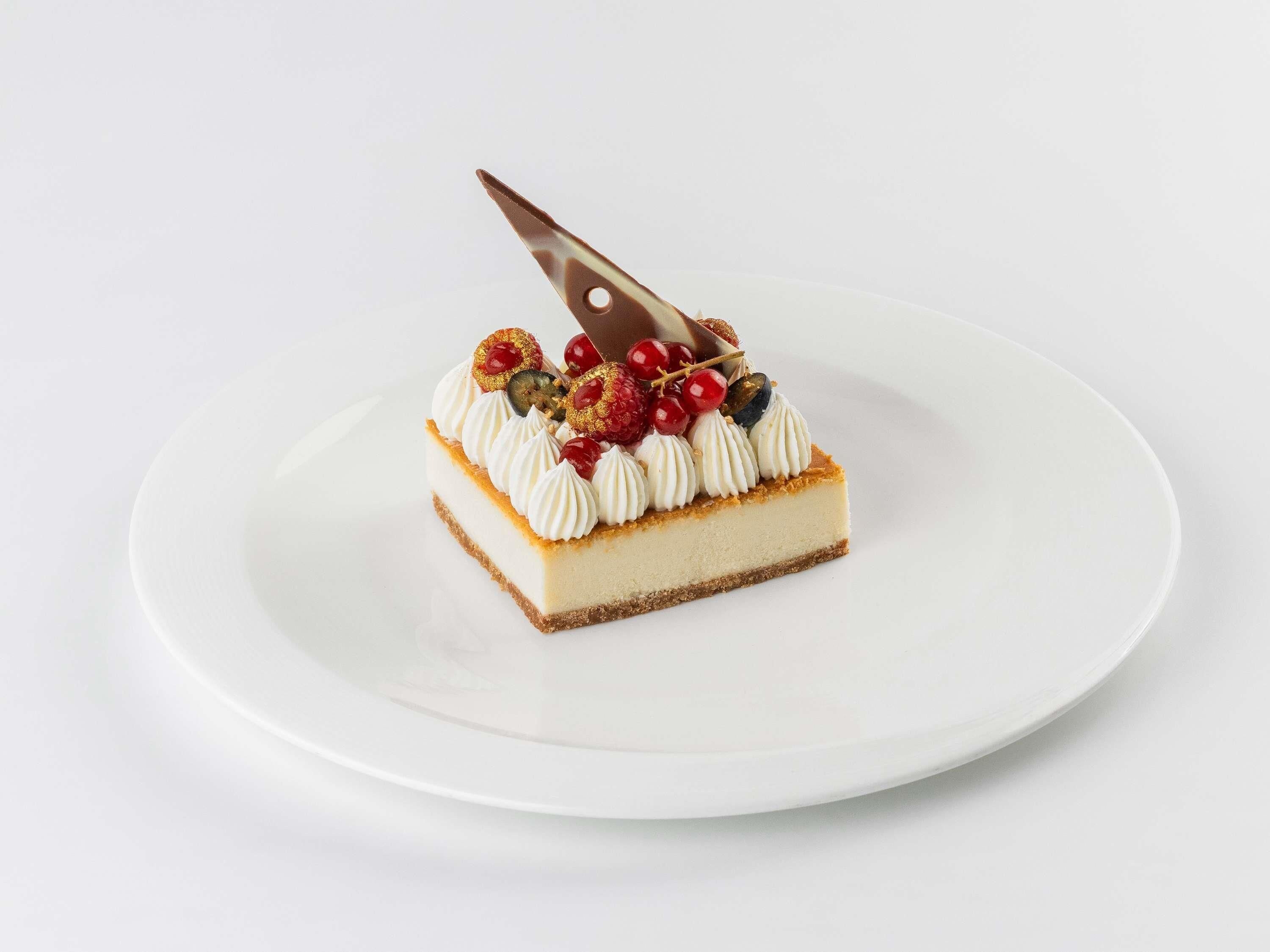 En enda bit cheesecake på en vit tallrik.