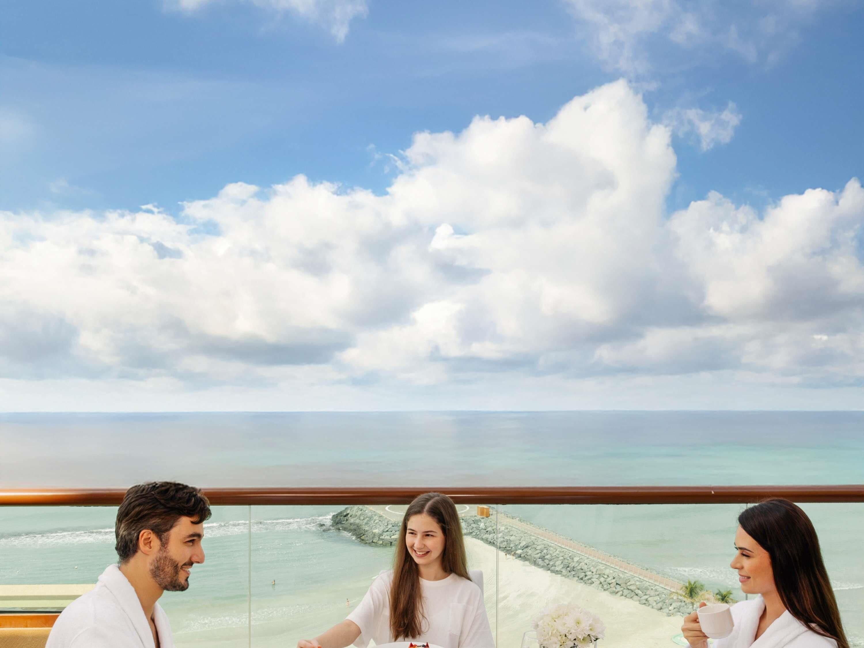 A balcony with a clear view of the ocean and a rocky shoreline.