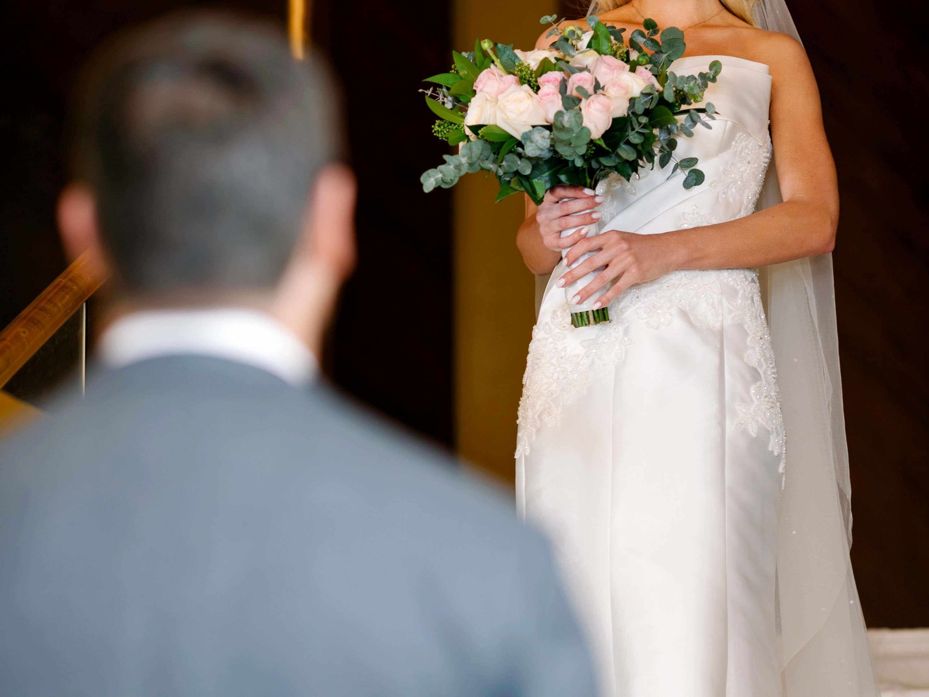 A wedding ceremony with a bride holding a bouquet.