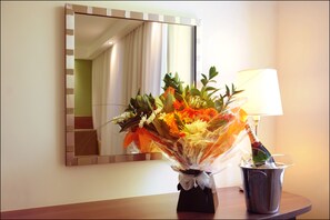A bouquet of flowers in a vase on a table next to a lamp and a mirror. - Hampton By Hilton Newcastle (Newcastle-upon-Tyne)