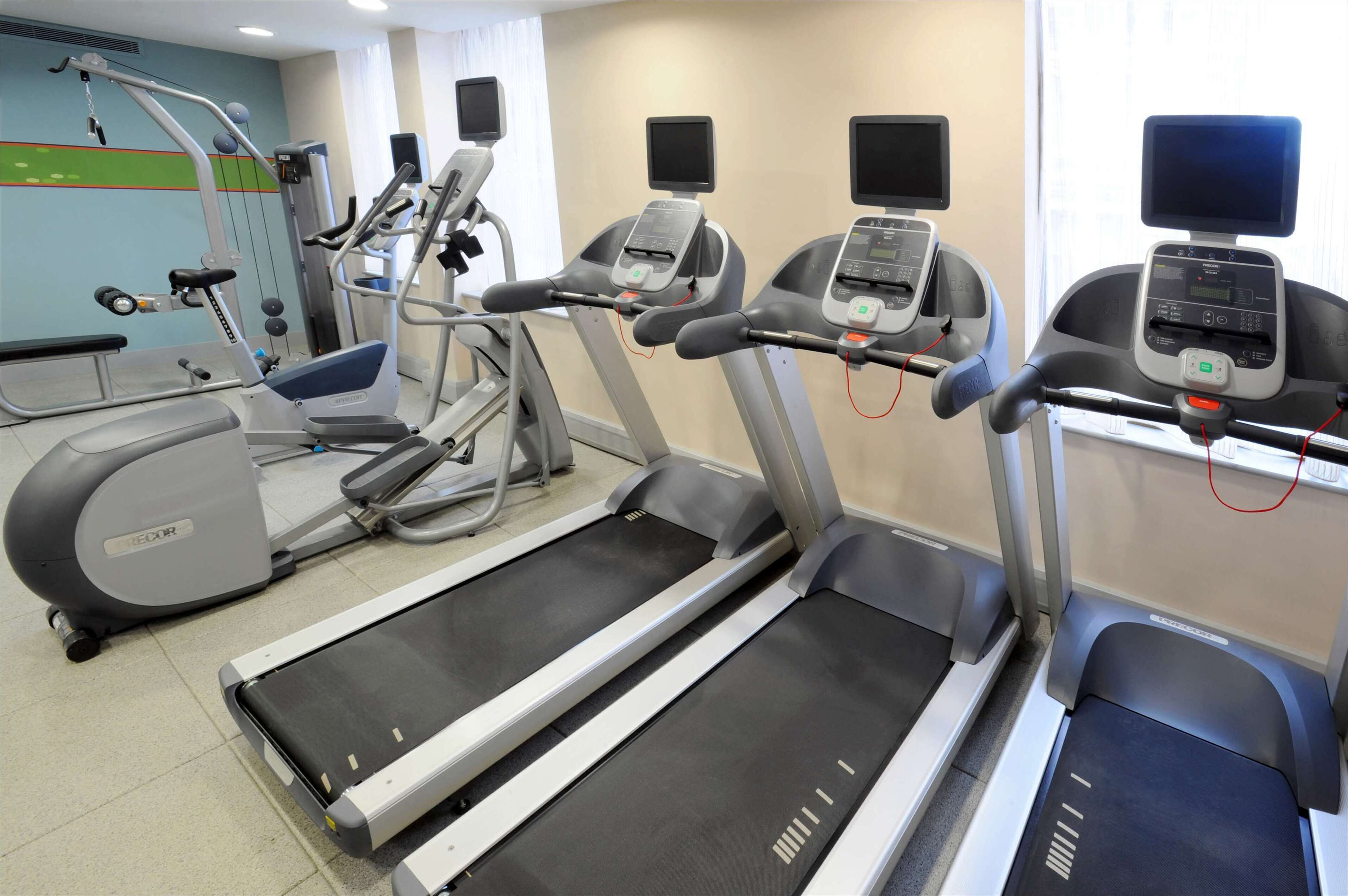 A gym with treadmills, elliptical machines, and weight equipment.