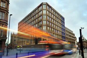 A modern building with a prominent 'Hampton' sign, featuring a classic architectural style with a corner tower. - Hampton By Hilton Newcastle (Newcastle-upon-Tyne)